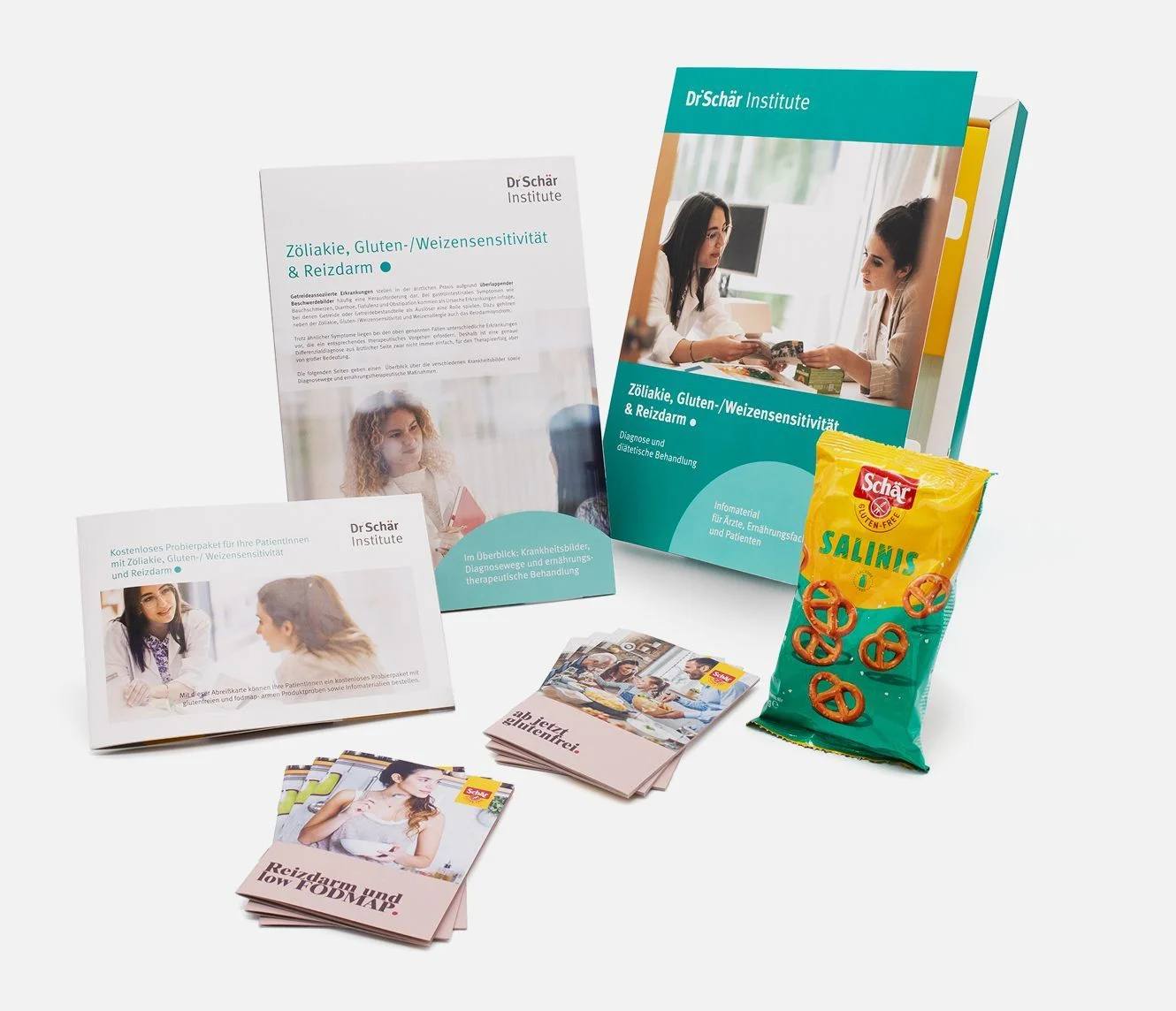 Brochures and a colorful folder about gluten sensitivity and celiac disease, with a bag of Schär snacks in the foreground